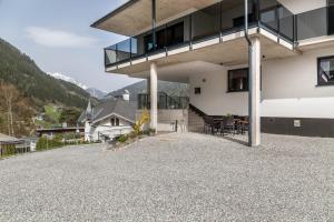 a house with a balcony and a table on a gravel driveway at Haus Florian Ski-in and Ski-out in See