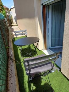 a table and a bench on a balcony at Charmant studio au rez de chaussée in Arbois