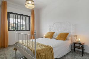 a bedroom with a white bed and a window at Casa El Molino in Montecorto +22 photos