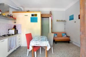 eine kleine Küche mit Tisch und Stühlen in der Unterkunft Acciuga House in Biassa