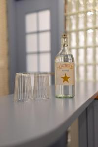 a bottle and two glasses sitting on a table at Casa Libertà Suites & Studios Piran in Piran