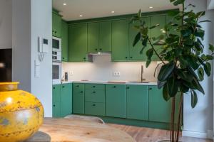 a green kitchen with a table and a vase at 'Salmosalar' Cangas de Onís in Cangas de Onís