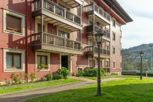 a pink apartment building with balconies and a street light at 'Salmosalar' Cangas de Onís in Cangas de Onís