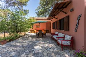a patio with chairs and a table and an umbrella at Villa Sole With Pool and Sauna in Lecce
