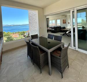 a dining room with a table and chairs and a view of the ocean at Villa Jasmina in Stomorska