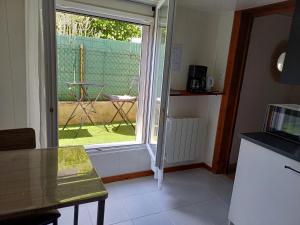 a kitchen with a sliding glass door to a yard at Charmant studio au rez de chaussée in Arbois +3 photos