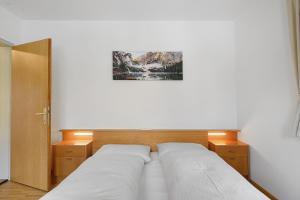 a bedroom with two white beds and a picture on the wall at Unterzerunhof 2 in Laion