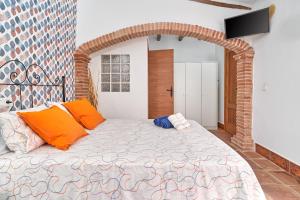a bedroom with a large bed with orange pillows at Estudio Quorum, centro de Nerja in Nerja