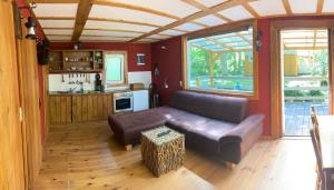 a living room with a leather couch and a kitchen at Haus Sonnenschein in Dranske