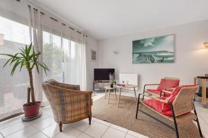a living room with a couch and chairs and a tv at Joli appartement quartier artistes in Camaret-sur-Mer