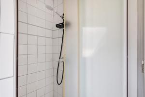 a shower with a shower head in a bathroom at Joli appartement quartier artistes in Camaret-sur-Mer +12 photos