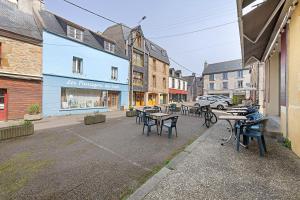 a street with tables and chairs in a city at Joli appartement quartier artistes in Camaret-sur-Mer