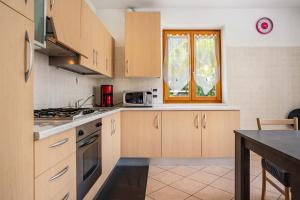 a kitchen with wooden cabinets and a table and a window at Apartment Villa Irma in Levico Terme