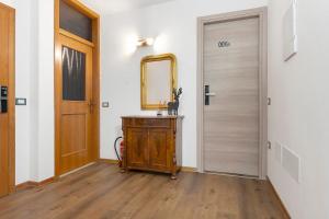 a hallway with a mirror and a wooden door at Bnb and Breakfast Pellizzano in Pellizzano