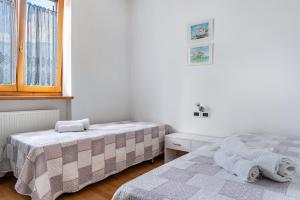 a bedroom with two beds and a window at Apartment Villa Irma in Levico Terme +25 photos