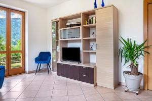 a living room with a tv and a blue chair at Apartment Villa Irma in Levico Terme