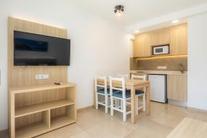 a small kitchen with a table and a tv in a room at Apartamento Bon Aire N1 in Cala Ferrera