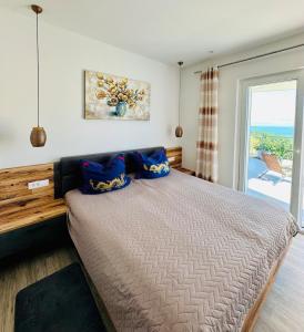 a bedroom with a bed with blue pillows on it at Villa Jasmina in Stomorska +126 photos