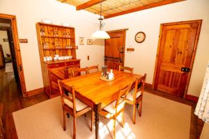 a dining room with a wooden table and chairs at De Kothuize 166 in Graaff-Reinet