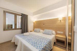 a hotel room with a bed and a window at Apartamento Bon Aire N1 in Cala Ferrera +13 photos