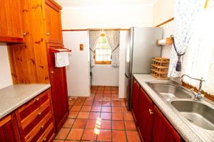 a kitchen with a sink and a refrigerator at De Kothuize 166 in Graaff-Reinet