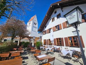 a group of tables and chairs in front of a building at Hotel Rusticone Hechendorf in Seefeld