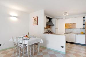 a white kitchen with a white table and chairs at Vallelaghi Escape in Terlago
