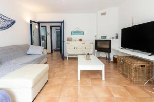 a living room with a couch and a flat screen tv at La caseta de Sa Riera in Begur