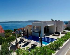 a house with a swimming pool with a view of the ocean at Villa Jasmina in Stomorska