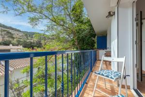 a balcony with a blue railing and a white chair at La caseta de Sa Riera in Begur