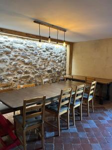 a table and chairs in a room with a stone wall at Gite les 4 Saisons in Ombre +18 photos