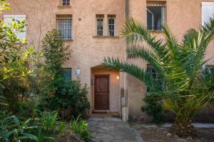 a house with a wooden door and some plants at Le Cocon Blanc - T3 - Gassin in Gassin