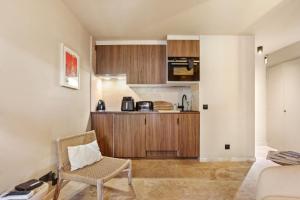 a kitchen with a couch and a chair in a room at Le Cocon Blanc - T3 - Gassin in Gassin