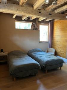 two beds in a room with wooden ceilings at Gite les 4 Saisons in Ombre