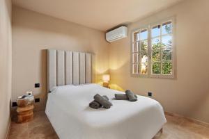 a bedroom with a white bed with two towels on it at Le Cocon Blanc - T3 - Gassin in Gassin +19 photos