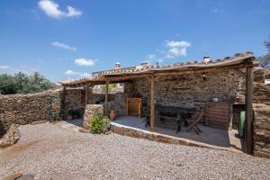 a stone house with a wooden pergola at Recanto d'Aldeia in Alcoutim