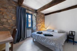 a bedroom with a bed and a stone wall at L'Ancrage - Maison 17è - Port in Camaret-sur-Mer