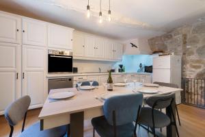 a kitchen with a table and chairs and a refrigerator at L'Ancrage - Maison 17è - Port in Camaret-sur-Mer