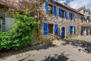 an old stone building with blue windows and blue shutters at L'Ancrage - Maison 17è - Port in Camaret-sur-Mer