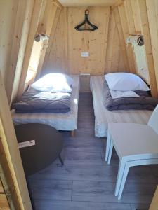 two beds in a small room with a table at Camping Les 2 Plages in Quend +76 photos