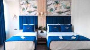two beds in a room with blue and white at Central Park Hotel İstanbul in Istanbul