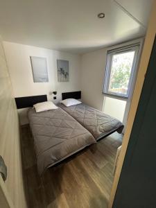 a bedroom with a bed and a window at Mobil Home - 3CH - 2 SDB - Clim - Wifi in Roquebrune-sur-Argens