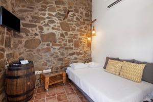 a room with a couch and a stone wall at Recanto d'Aldeia in Alcoutim