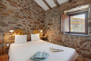 a bedroom with a bed in a stone wall at Recanto d'Aldeia in Alcoutim +50 photos