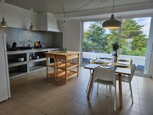 a kitchen with a table and chairs and a dining room at Residencias Requinte T3 Espacoso com Terraco e Vista in São Roque do Pico