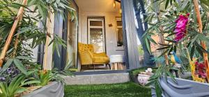 a front porch with a yellow chair and plants at Center Lux Apartment Marijana in Novi Sad
