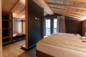 a bedroom with a large bed and a large window at Chalet Ice Villa Genf Spa - Relax in Livigno