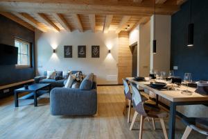 a living room with a table and a blue couch at Chalet Ice Villa Genf Spa - Relax in Livigno