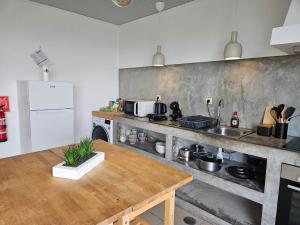 a kitchen with a wooden table in a kitchen at Residencias Requinte T3 Espacoso com Terraco e Vista in São Roque do Pico