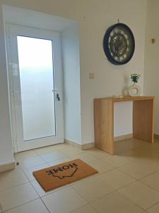 a room with a door and a rug and a table at Residencias Requinte T3 Espacoso com Terraco e Vista in São Roque do Pico